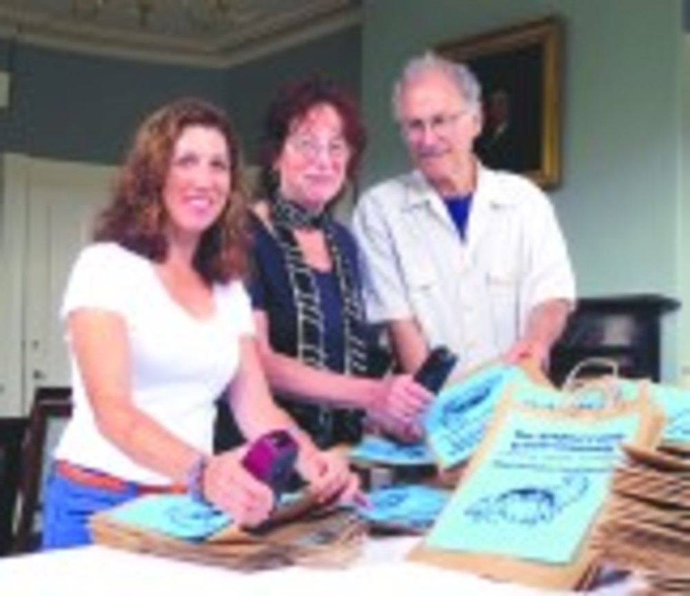  NEWPORT – Leslie Saunders, left, of Temple Shalom, Irene Glasser of Touro Synagogue and Howard Newman of Newport Havurah, prepare shopping bags before the High Holy Days; the bags were distributed to members of Temple Shalom, Touro Synagogue and the Newport Havurah after Rosh Hashanah services. 	Members of the Newport County Jewish community joined forces to sponsor a community High Holiday Food Drive. Food donations will be split between The Louis and Goldie Chester Full Plate Kosher Food Pantry and the Martin Luther King Food Bank in Newport. /BEA ROSS